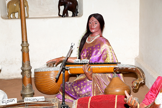 Photograph of a wax sculpture of a woman playing the veena